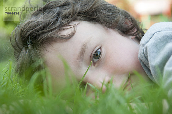 Junge im Gras liegend  Portrait