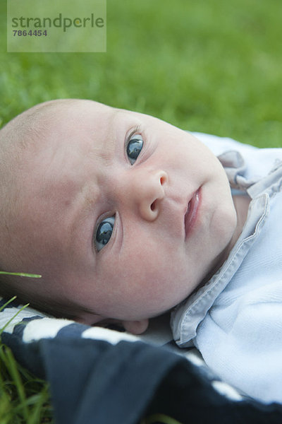 Junge auf Gras liegend  Portrait