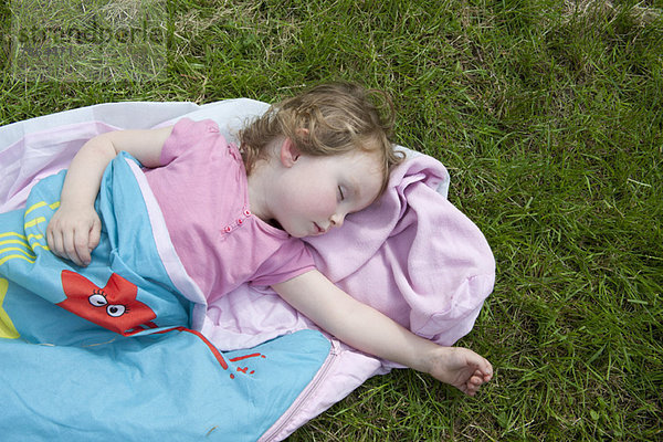 Kleines Mädchen schlafend im Freien