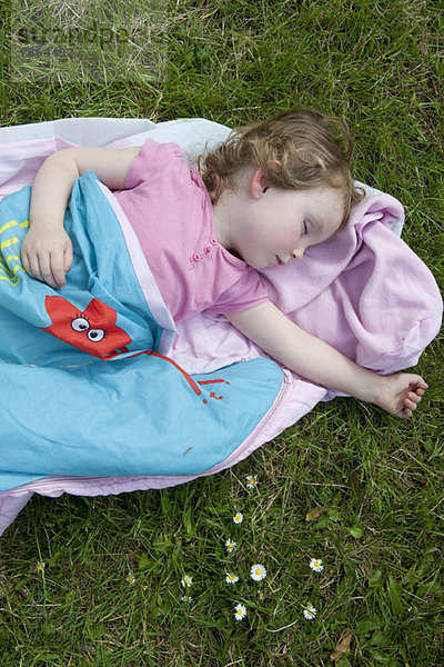 Kleines Mädchen schlafend im Freien