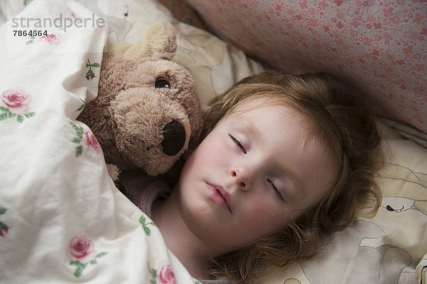 Kleines Mädchen schläft mit Teddybär