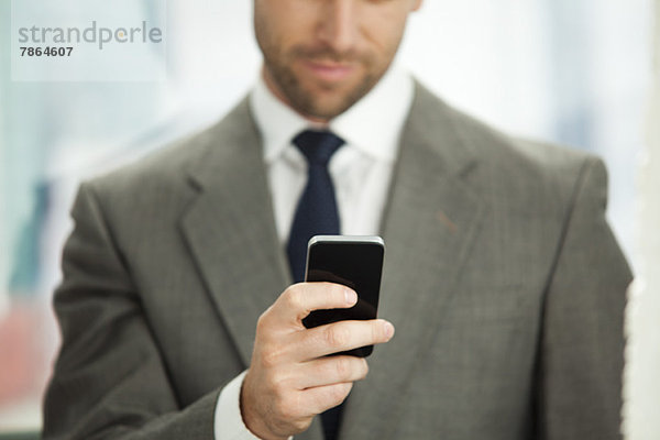 Geschäftsmann sendet SMS auf dem Handy  abgeschnitten