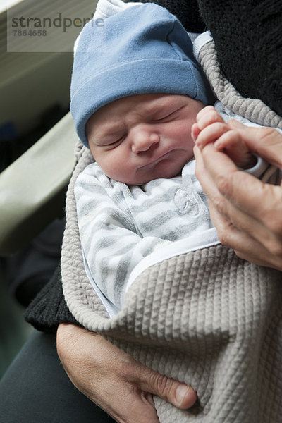 Neugeborenes Baby mit erwachsenem Finger