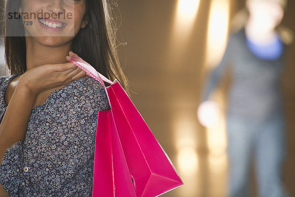 Junge Frau mit Einkaufstaschen  beschnitten