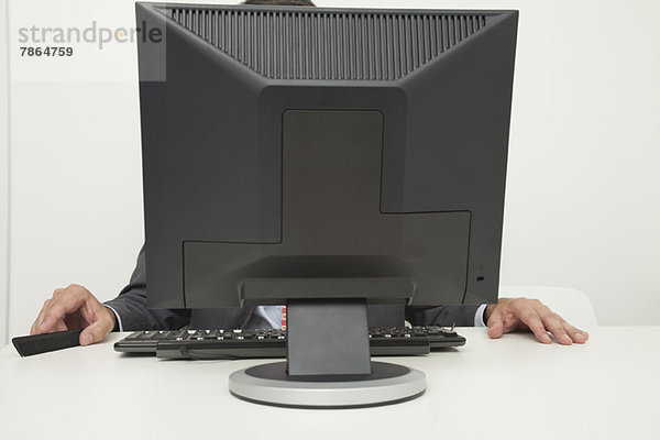 Mann sitzt vor dem Computerbildschirm