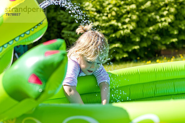 Blondes Mädchen spielt im Garten