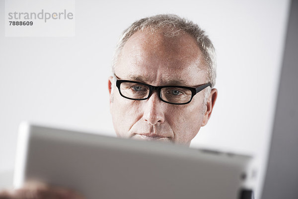 Reifer Mann mit einem Tablet-PC