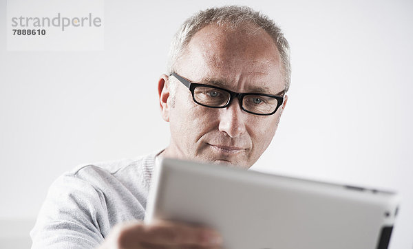 Reifer Mann mit einem Tablet-PC