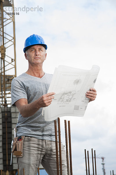 Bauarbeiter mit Plan auf einer Baustelle