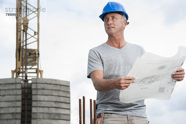 Bauarbeiter mit Plan auf einer Baustelle