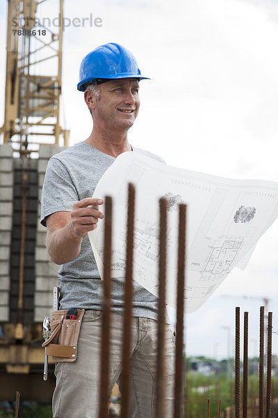 Bauarbeiter mit Plan auf einer Baustelle