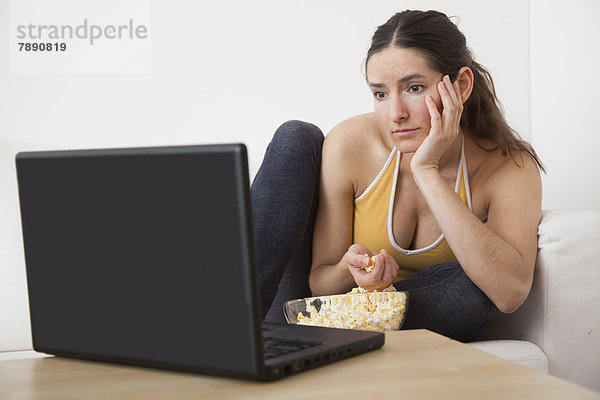 Europäer  Frau  Notebook  essen  essend  isst  Popcorn