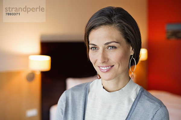 Frau lächelt in einem Hotelzimmer