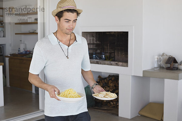 Mann  der Teller mit Essen trägt