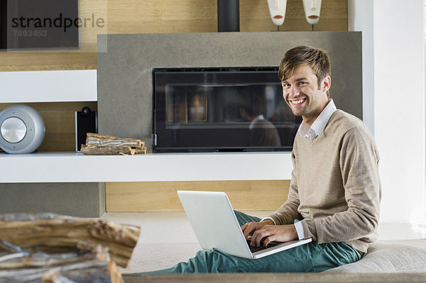 Portrait eines lächelnden Mannes mit einem Laptop