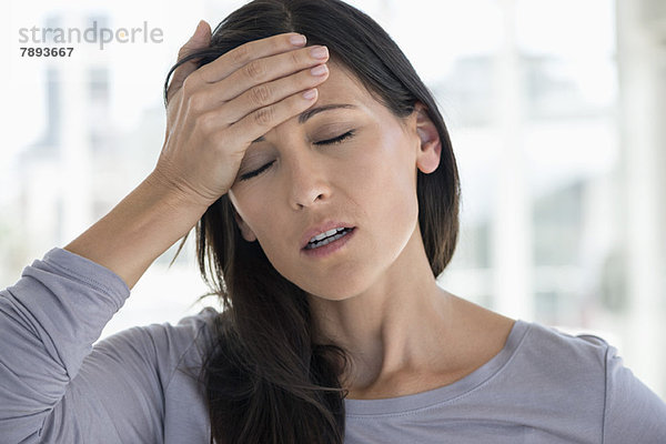 Nahaufnahme einer Frau mit Kopfschmerzen