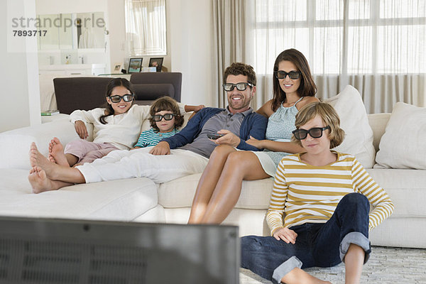Familie beim Fernsehen zu Hause mit 3D-Brille