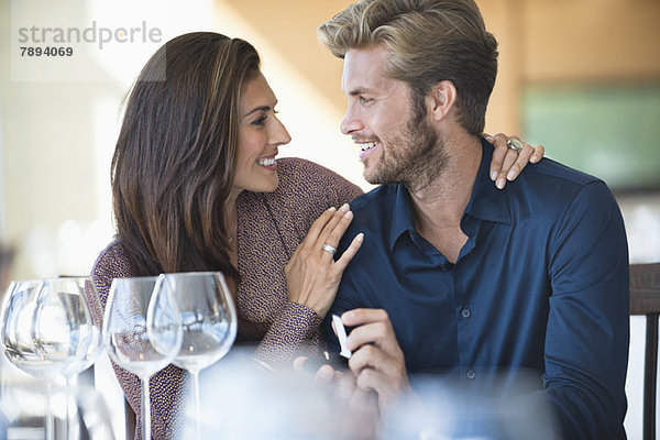 Mann mit Verlobungsring  der seine Freundin in einem Restaurant vorschlägt.