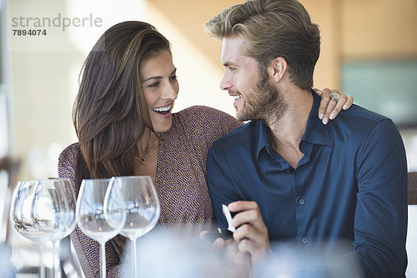 Mann mit Verlobungsring  der seine Freundin in einem Restaurant vorschlägt.