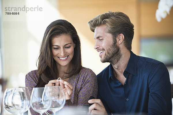 Mann  der seiner Freundin in einem Restaurant einen Verlobungsring schenkt.