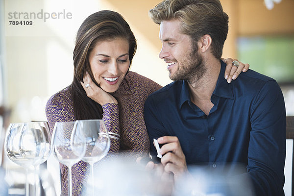 Mann mit Verlobungsring  der seine Freundin in einem Restaurant vorschlägt.