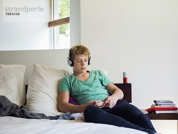 Teenager-Junge hört Musik auf dem Handy