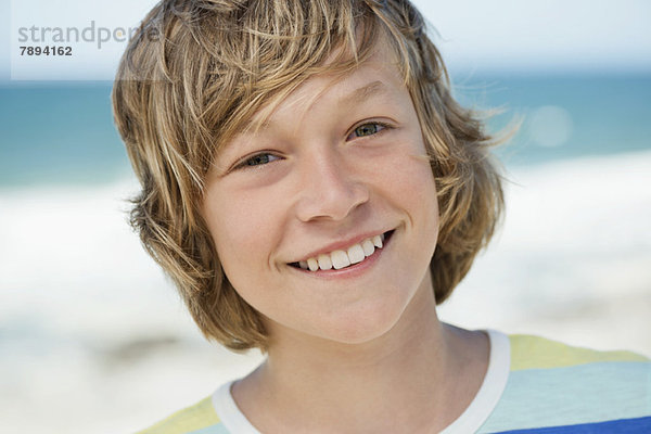 Porträt eines am Strand lächelnden Jungen