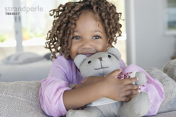 Porträt eines lächelnden Mädchens mit einem Teddybären