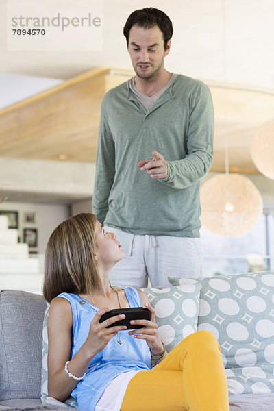 Mann schimpft mit seiner Tochter wegen des Videospiels.