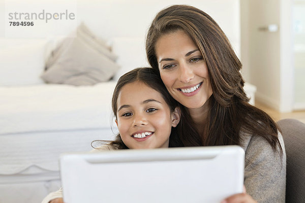 Frau und ihre Tochter betrachten ein digitales Tablett