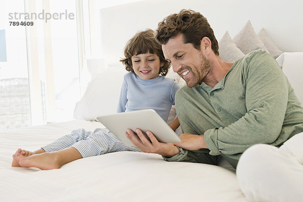 Mann zeigt seinem Sohn ein digitales Tablett
