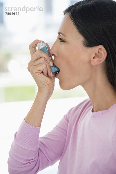 Nahaufnahme einer Frau mit einem Asthma-Inhalator