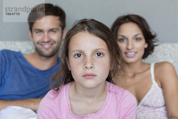 Porträt eines Mädchens mit ihren Eltern im Hintergrund
