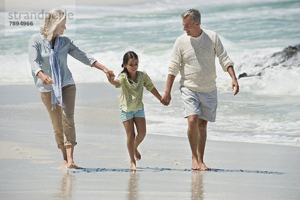 Mädchen beim Spaziergang mit ihren Großeltern am Strand