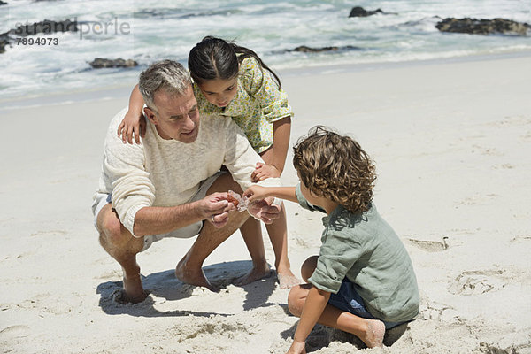 Kinder mit ihrem Großvater am Strand