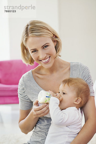 Frau füttert ihr Baby mit einer Flasche Milch.