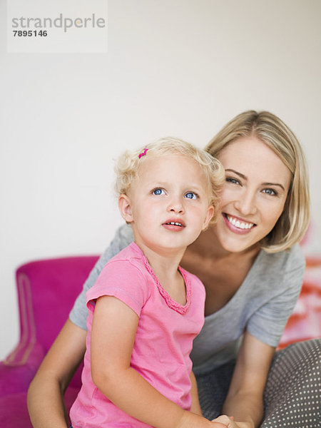 Lächelnde Frau sitzend mit ihrer Tochter