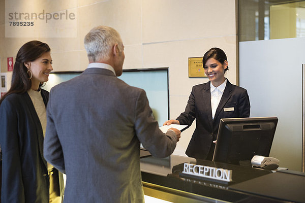 Geschäftspaar beim Einchecken ins Hotel