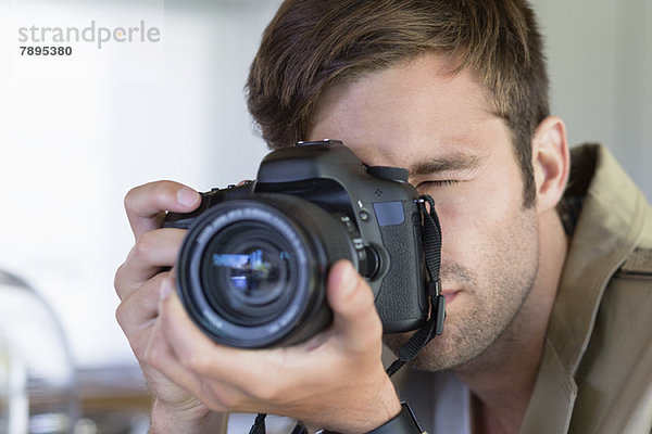 Nahaufnahme eines Mannes  der mit einer Kamera fotografiert.