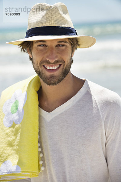 Porträt eines am Strand lächelnden Mannes