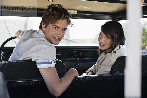 Porträt eines Paares in einem SUV sitzend und lächelnd