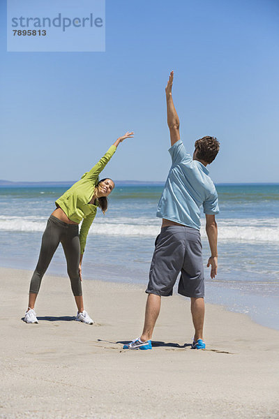 Frau und ihr Trainer beim Training am Strand