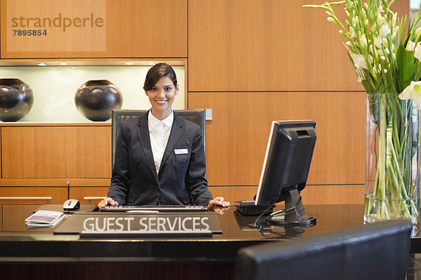 Porträt einer lächelnden Empfangsdame an der Hotelrezeption