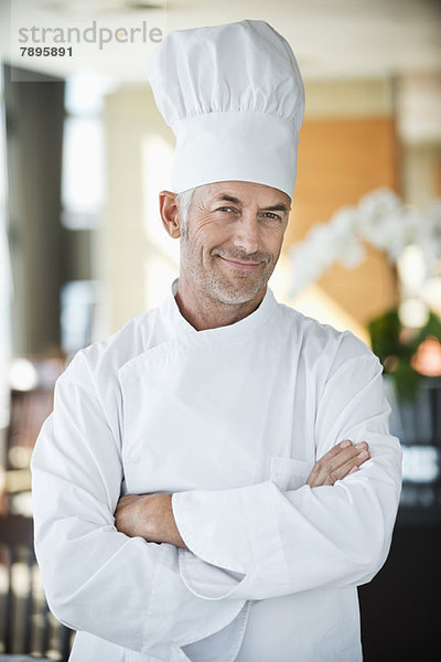 Porträt eines Küchenchefs  der mit gekreuzten Armen lächelt