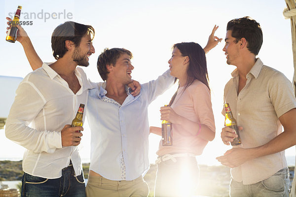 Vier Freunde genießen Bier auf der Party