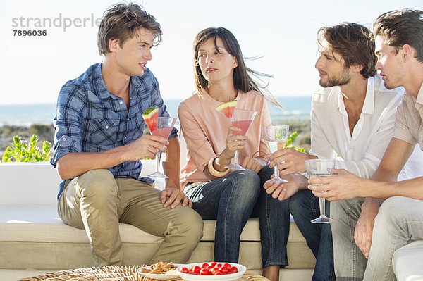 Gruppe von Freunden  die im Urlaub im Freien Getränke genießen.