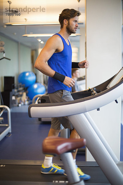 Mann läuft auf einem Laufband in einem Fitnessstudio