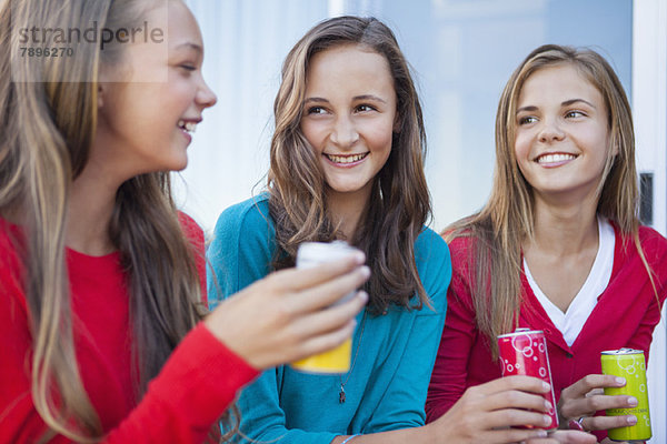 Nahaufnahme von drei Mädchen mit Erfrischungsgetränkedosen