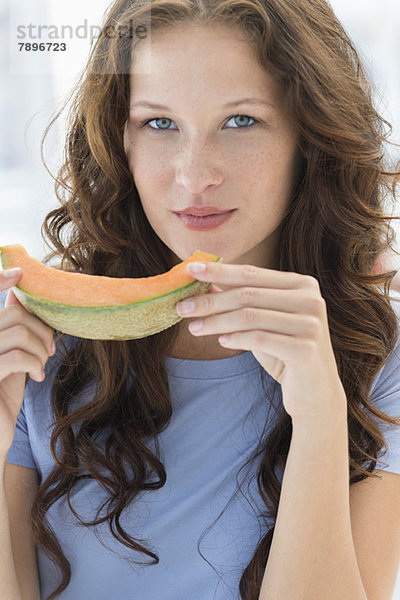 Porträt einer Frau beim Melonenessen