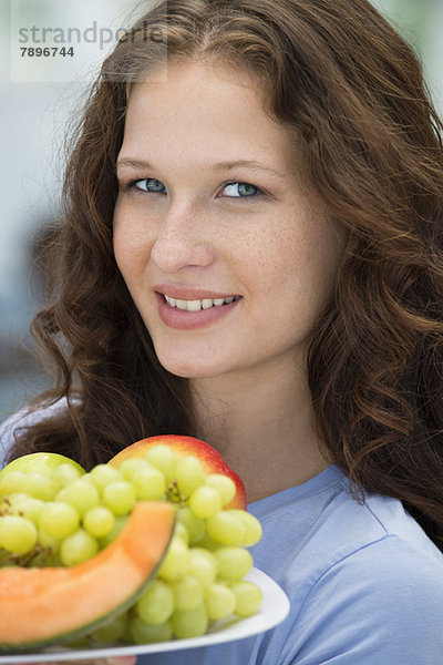 Lächelnde Frau mit einem Obstteller